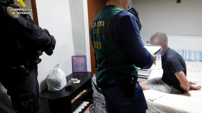 Agentes de la Guardia Civil inspeccionando una vivienda y deteniendo a uno de los implicados.